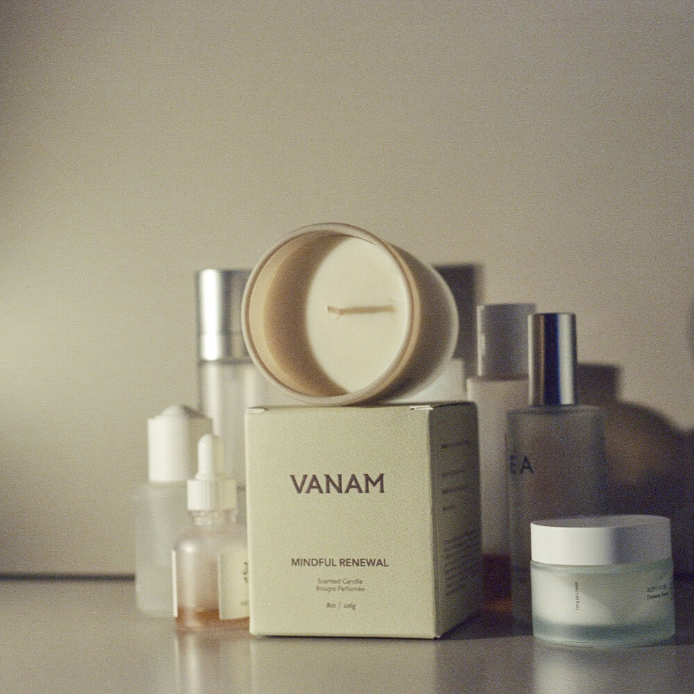 Vanam beeswax candle surrounded by modern skincare essentials